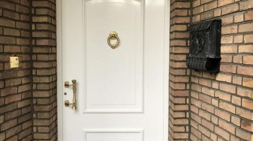 Weiße Haustür mit goldenem Türklopfer in Neuss