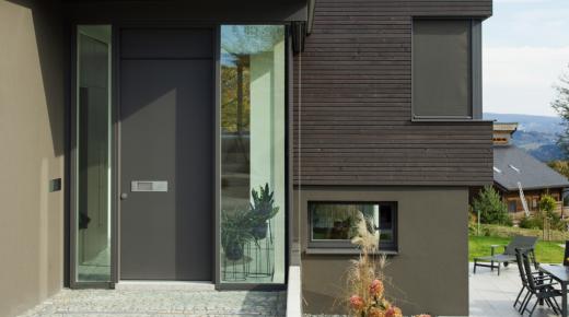 dunkelgraue-haustuer-mit-zwei-seitenteilen-im-neubau