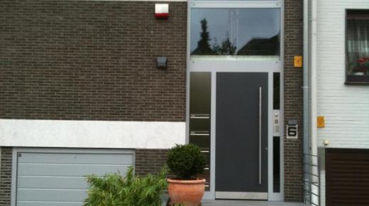 Graue Haustür mit silbernen Aluminium Spritzschutz